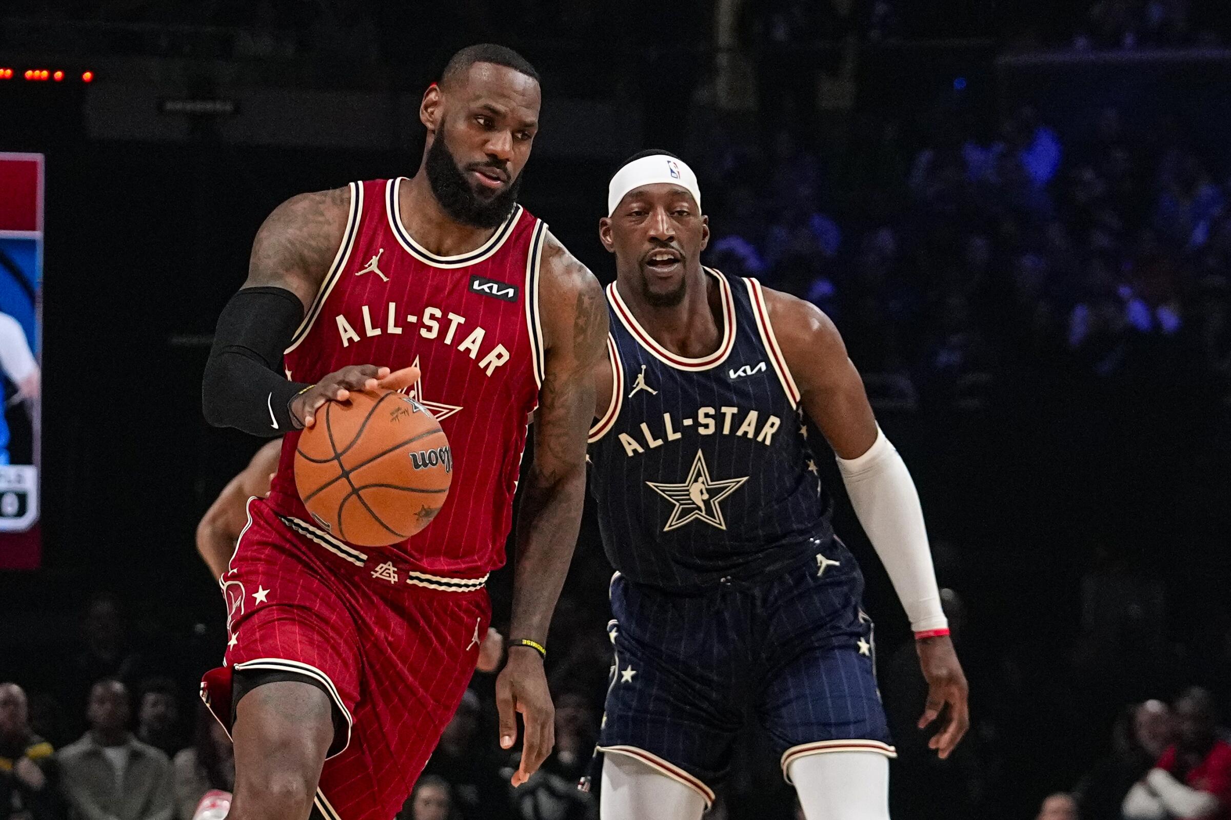 Lakers star LeBron James, left, drives past Miami Heat center Bam Adebayo during the first half of the NBA All-Star Game.