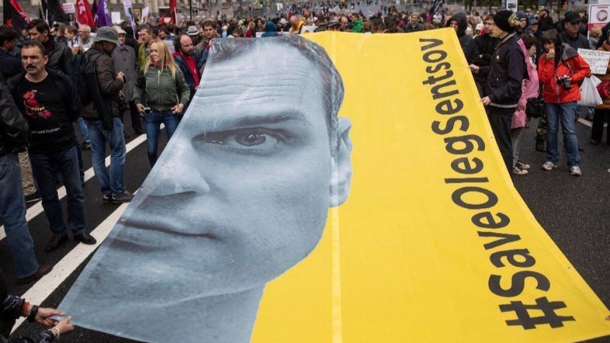 Protesters hold a poster with the image of political prisoner Oleg Sentsov at a Moscow rally June 10.