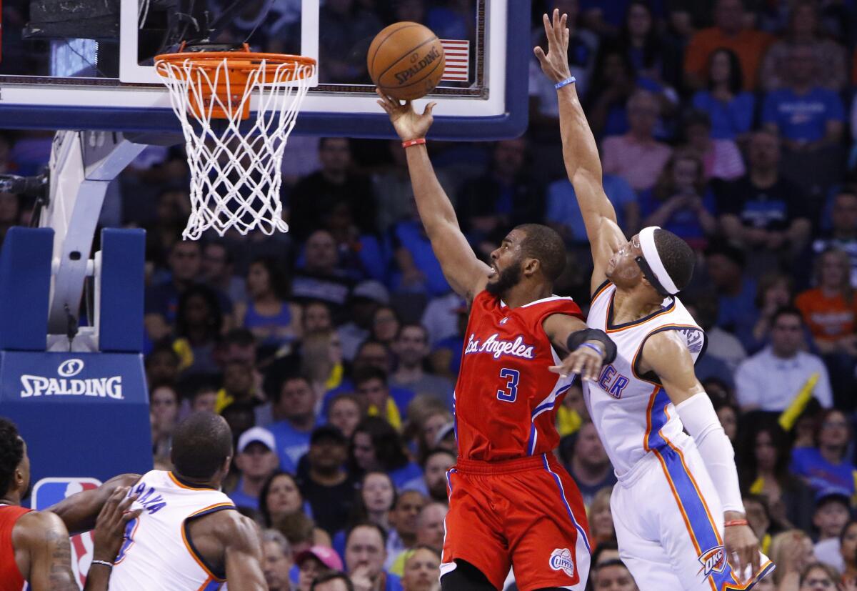 Point guard Chris Paul lays up a basket in front of Thunder point guard Russell Westbrook during the second half of the Clippers' 120-108 win.