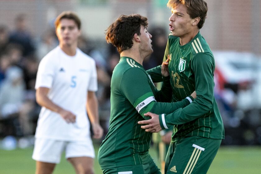 Edison's Tai Khoshkbariie, left, celebrates with Mikey White, right, after he scores a goal against Corona del Mar.