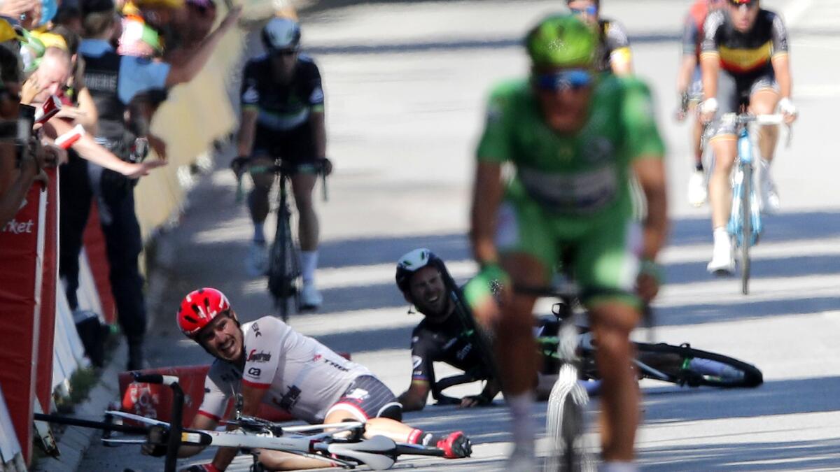 Germany's John Degenkolb, left, and Britain's Mark Cavendish hit the pavement after crashing during the fourth stage of the Tour de France on Tuesday.