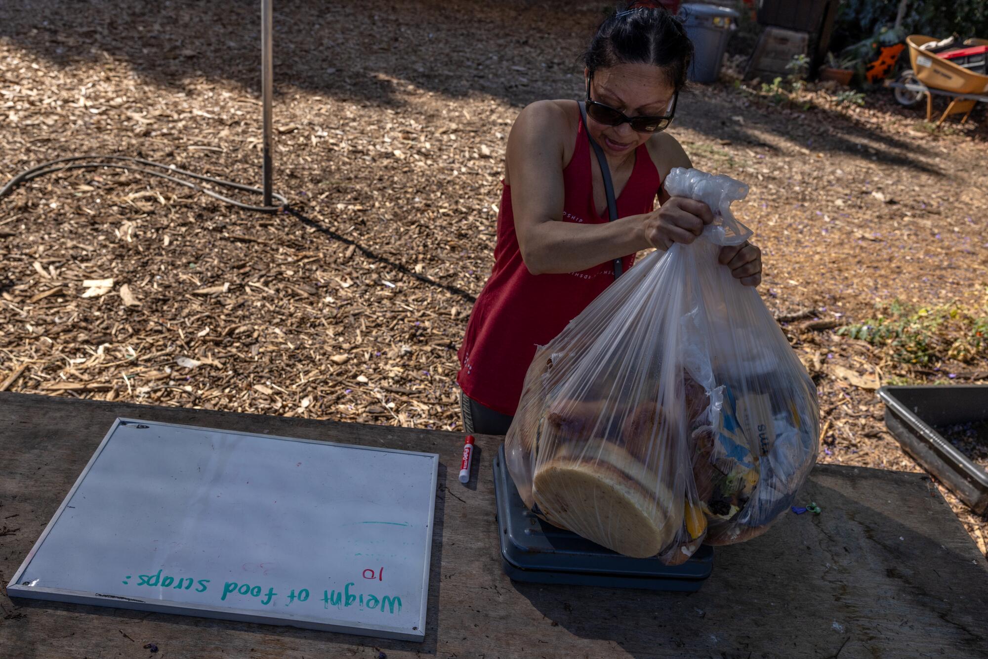 Sandra Torres brings bags of food scraps for composting at LA Compost.