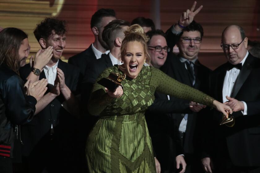 Adele reacts to winning the award for song of the year for "Hello." She also won record of the year.