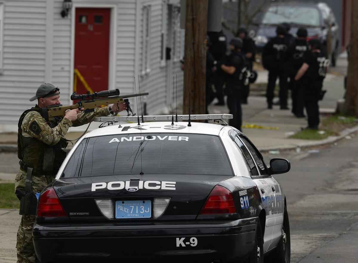 A Police SWAT team sniper keeps watch as the team makes house to house searches in Watertown, Massachusetts.