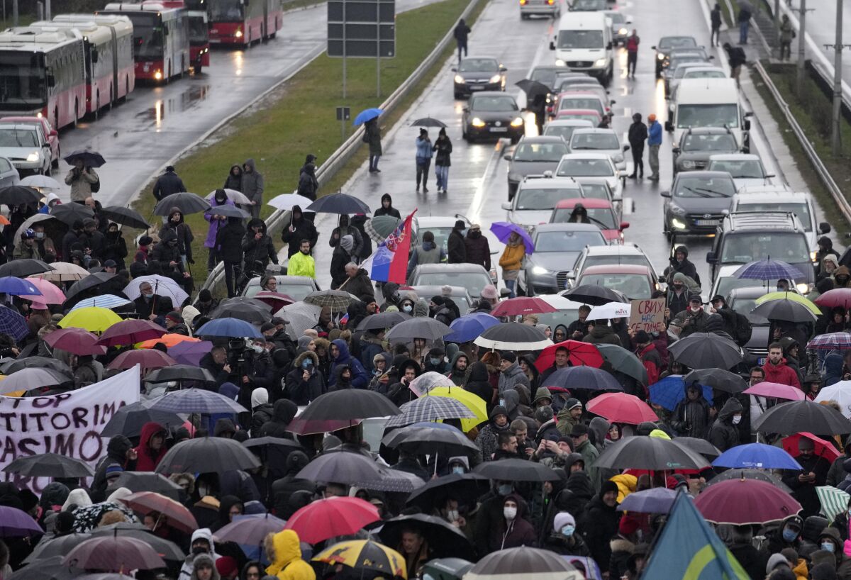 Environmental protesters stand on the highway during a protest in Belgrade, Serbia, on Dec. 11, 2021. Serbia has suspended a plan that would allow mining giant Rio Tinto launch a lithium mine in the west of the country after protests by environmentalists which have shaken the country’s populist leadership. A local council of the town of Loznica in western Serbia, where the excavations were to start in the near future, voted on Thursday to suspend a regional development plan. (AP Photo/Darko Vojinovic, File)