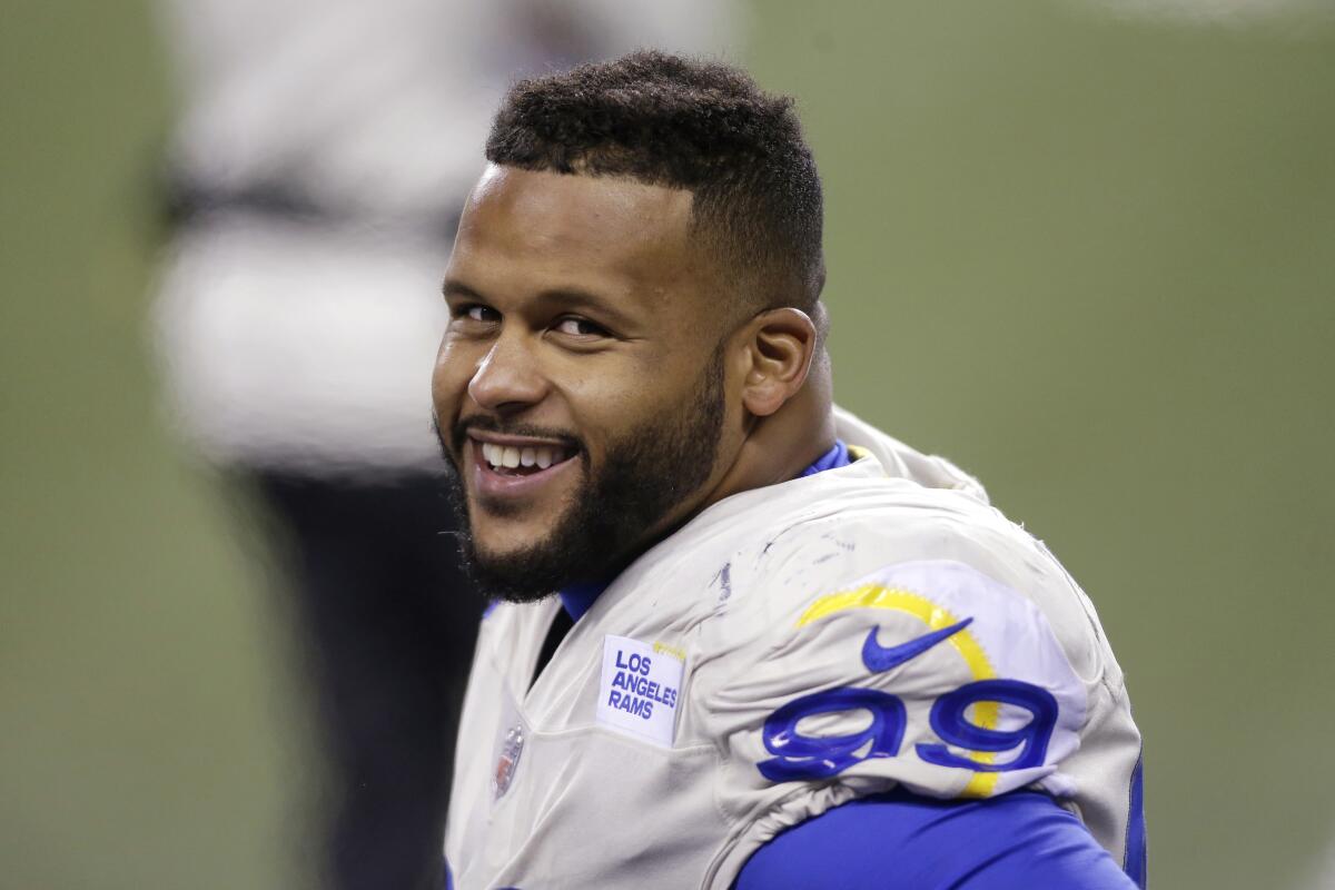 Rams defensive end Aaron Donald smiles as he stands on the sideline.