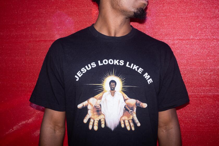 Brandon Anyanwu, 24, Inglewood, poses for a portrait showing off their t-shirt during the Leimert Park Rising: Juneteenth Festival on Saturday, June 18, 2022. "Jesus looks like us, you feel me? We gotta show our knowledge of ourselves."