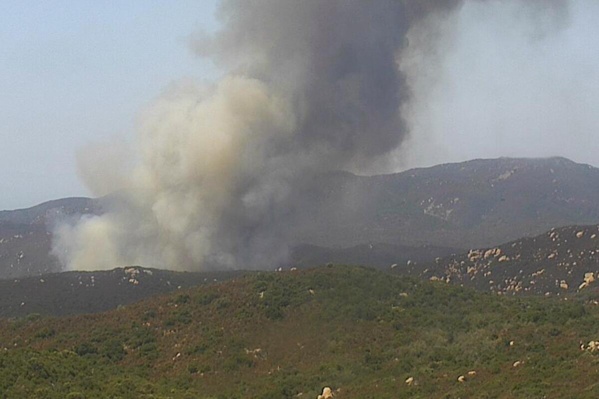 A plume of smoke behind a ridge.