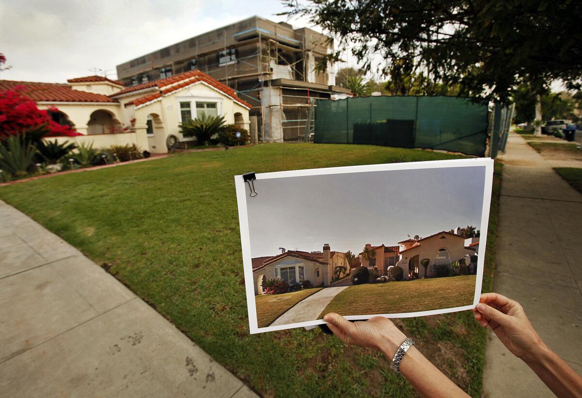 Traci Considine shows a "before" photo of a home under construction in her Faircrest Heights neighborhood in Los Angeles on March 14, 2014.