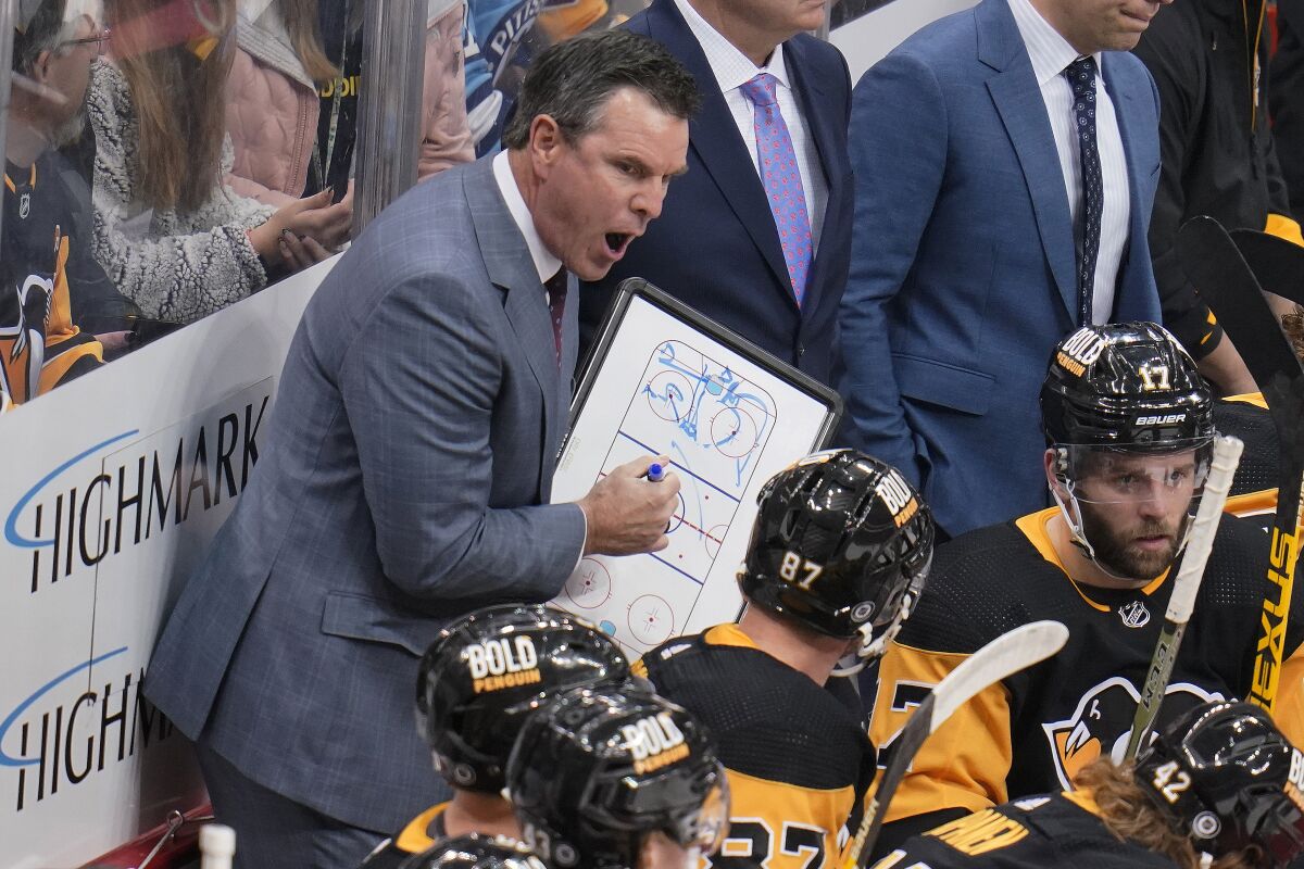 Pittsburgh Penguinss coach Mike Sullivan gives instruction to Sidney Crosby (87) during the first period of the team's NHL hockey game against the St. Louis Blues in Pittsburgh, Wednesday, Jan. 5, 2022. The Penguins won 5-3. (AP Photo/Gene J. Puskar)