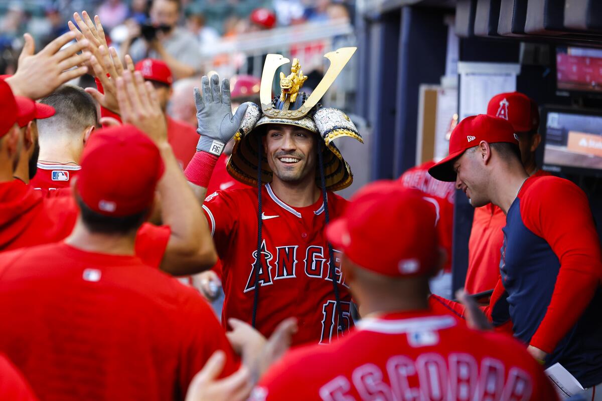 Angels' Randal Grichuk celebrates in the dugout after hitting a home run.
