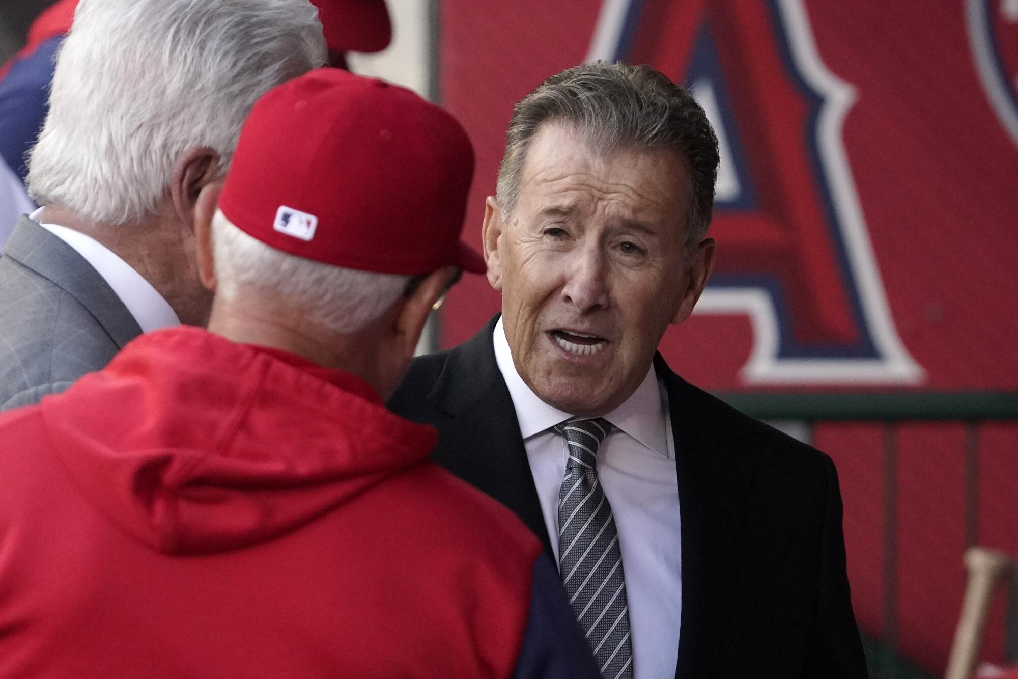 Angels owner Arte Moreno, right, talks with manager Joe Maddon before a game against Cleveland on April 26, 2022.