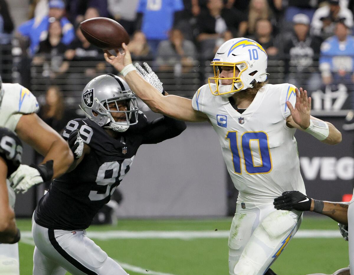 Chargers quarterback Justin Herbert passes under pressure against the Raiders.