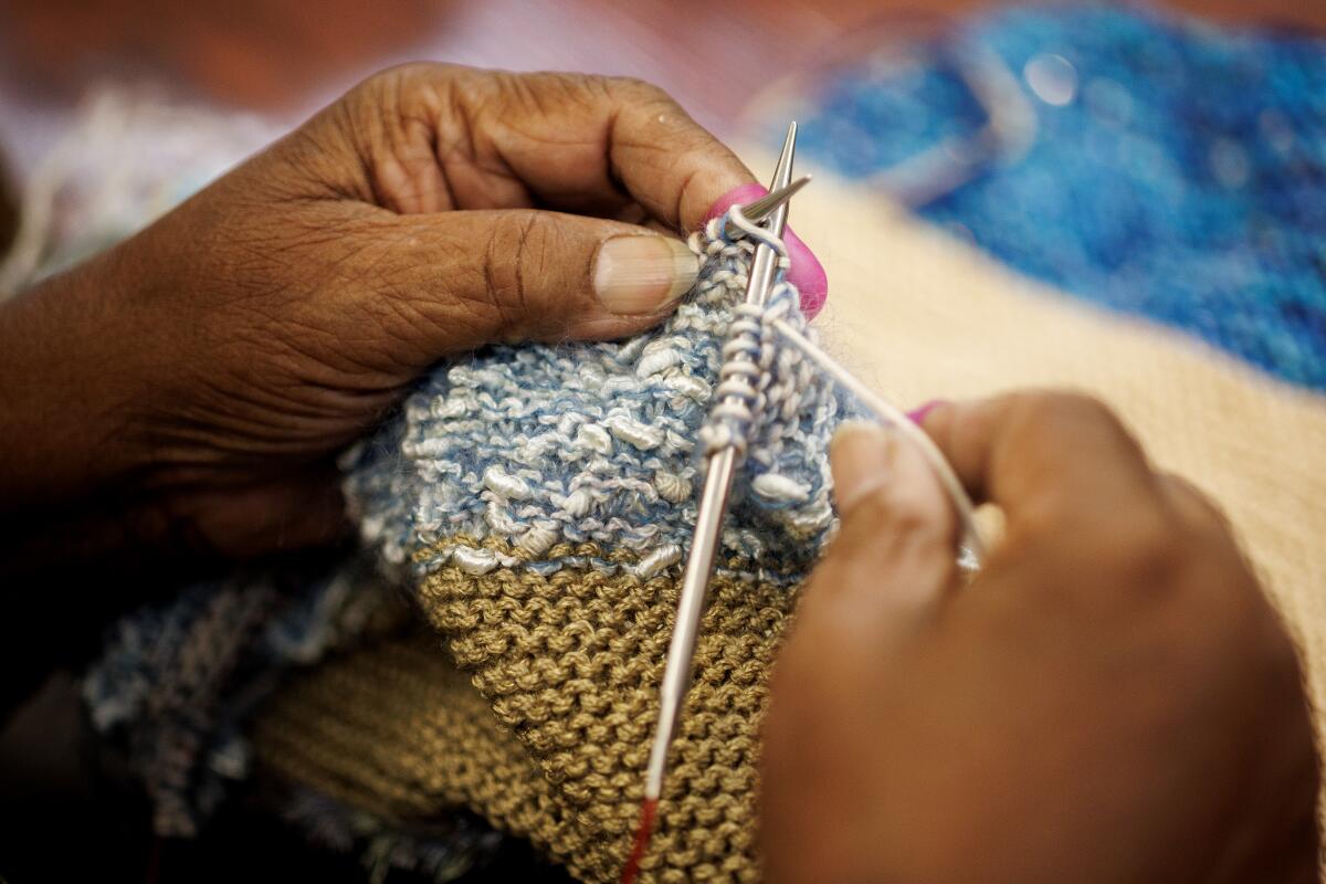 Chris Parker of Los Angeles works her needles through yarn for a sweater 