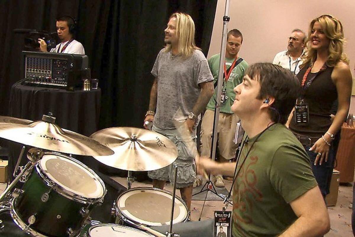Action Man Liam Gowing works the drums with Vince Neil of Motley Crue at his side.
