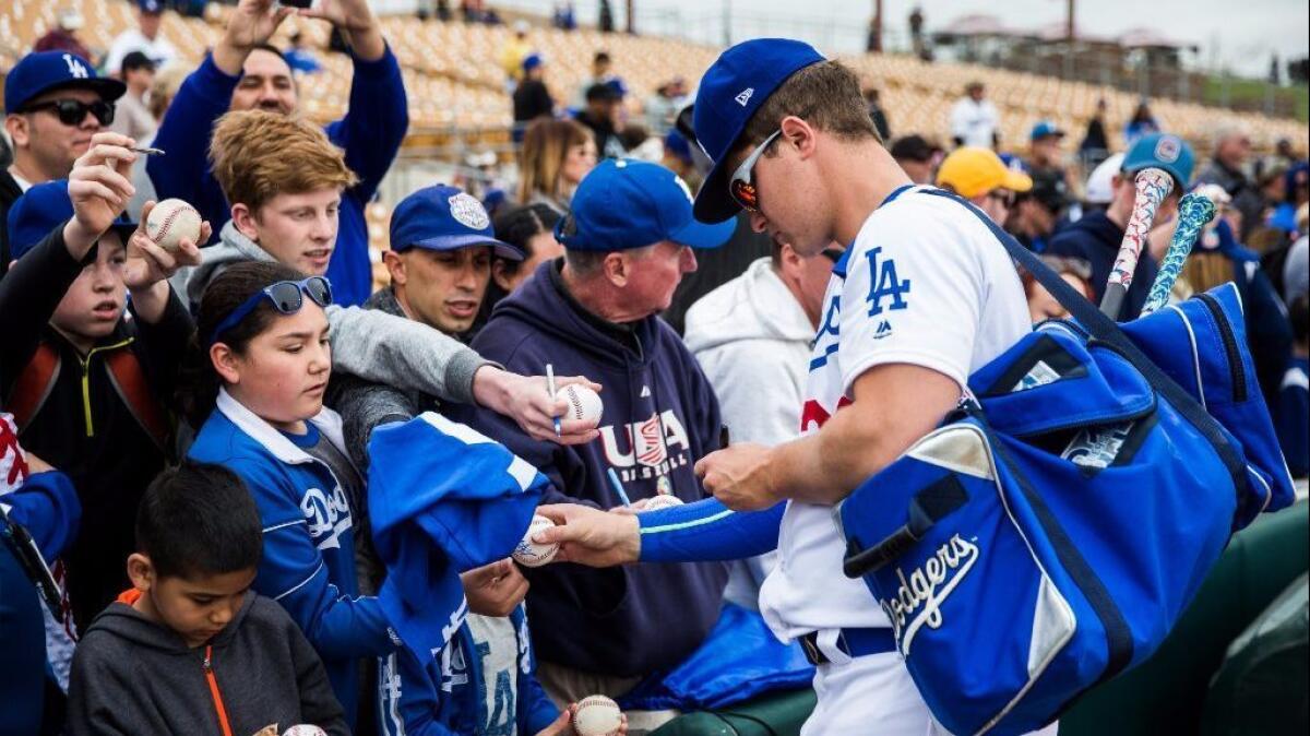 Dodgers center fielder Joc Pederson signs autographs for fans before a spring-training game against the Rockies on Feb. 27. The team is working on a deal to have 10 games broadcast on Channel 5.