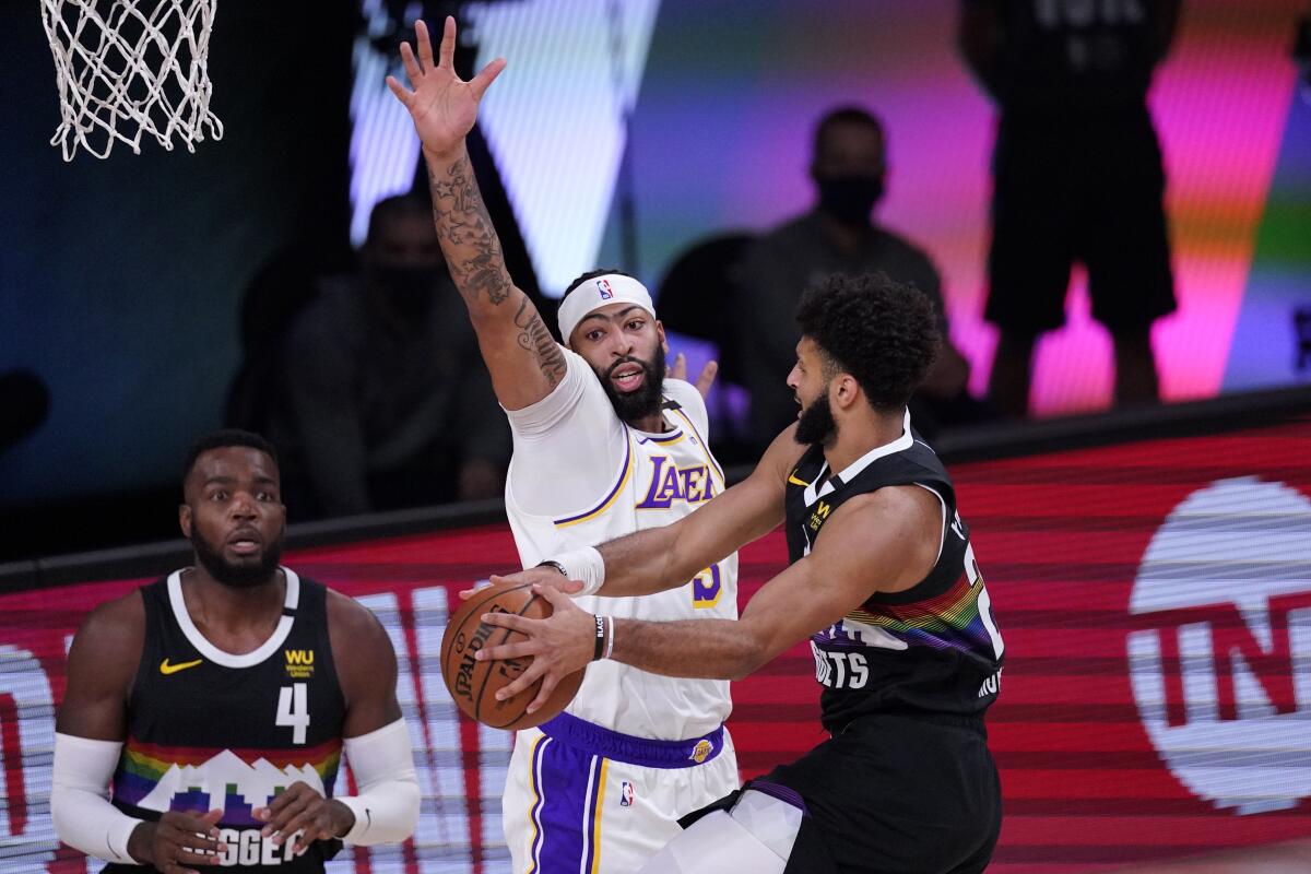 Nuggets guard Jamal Murray looks to pass to teammate Paul Millsap as Lakers forward Anthony Davis defends during Game 3.