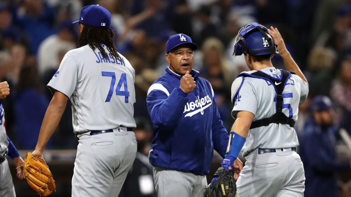Manager Dave Roberts congratulates Austin Barnes and Kenley Jansen after the Dodgers defeated the San Diego Padres on Friday.