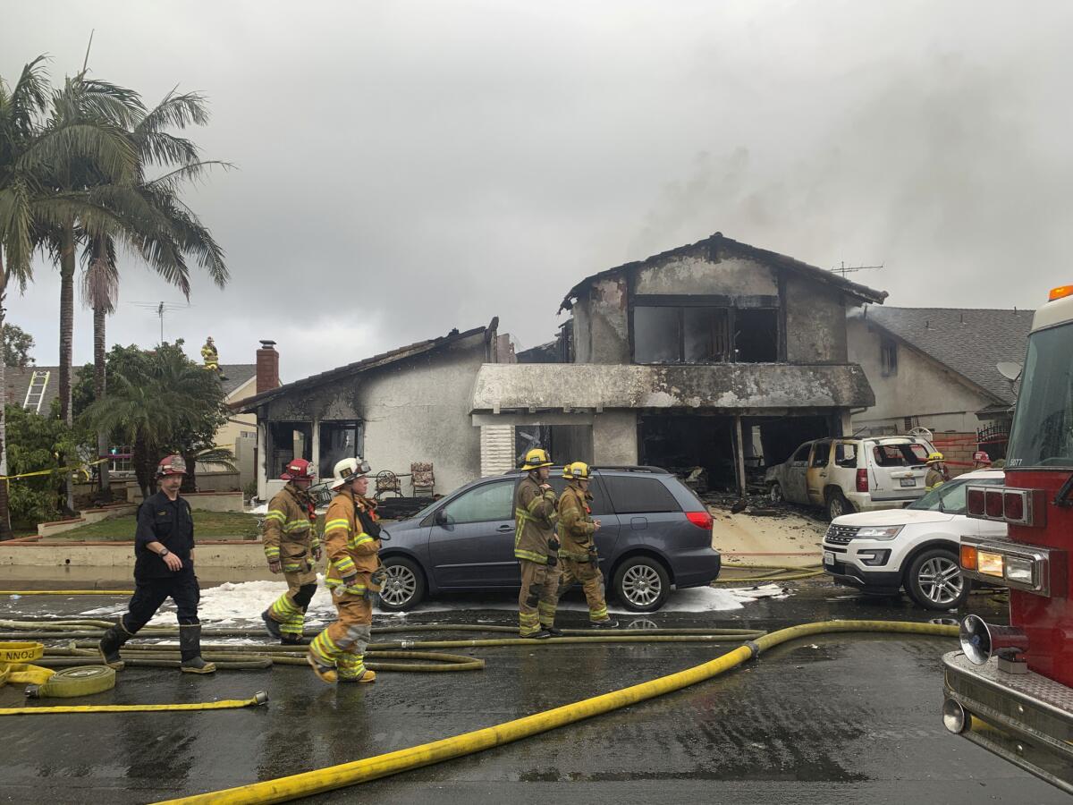 Varios bomberos trabajan en el sitio donde una avioneta se estrelló contra una casa en Yorba Linda, California, el domingo 3 de febrero de 2019. (AP Foto/Alex Gallardo)
