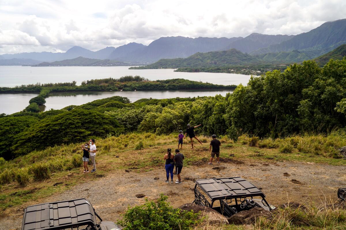 People on a Kuala Ranch ATV Raptor Tour look out towards Moili'i Fishpond and Kaneohe Bay.