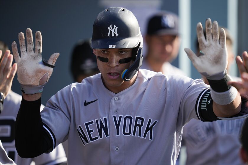 New York Yankees' Aaron Judge (99) celebrates in the dugout after hitting a home run during the sixth inning.