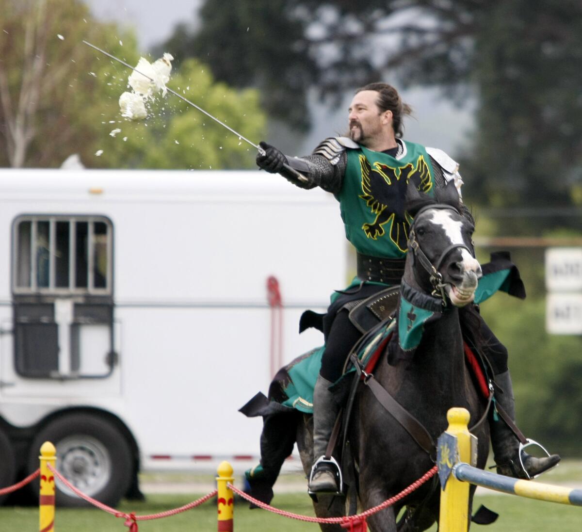 Knight Jason Houlihan slices through a cabbage with his sword during medieval jousting demonstration for Around The World in a Day at John Muir Middle School in Burbank on Friday, March 21, 2014.
