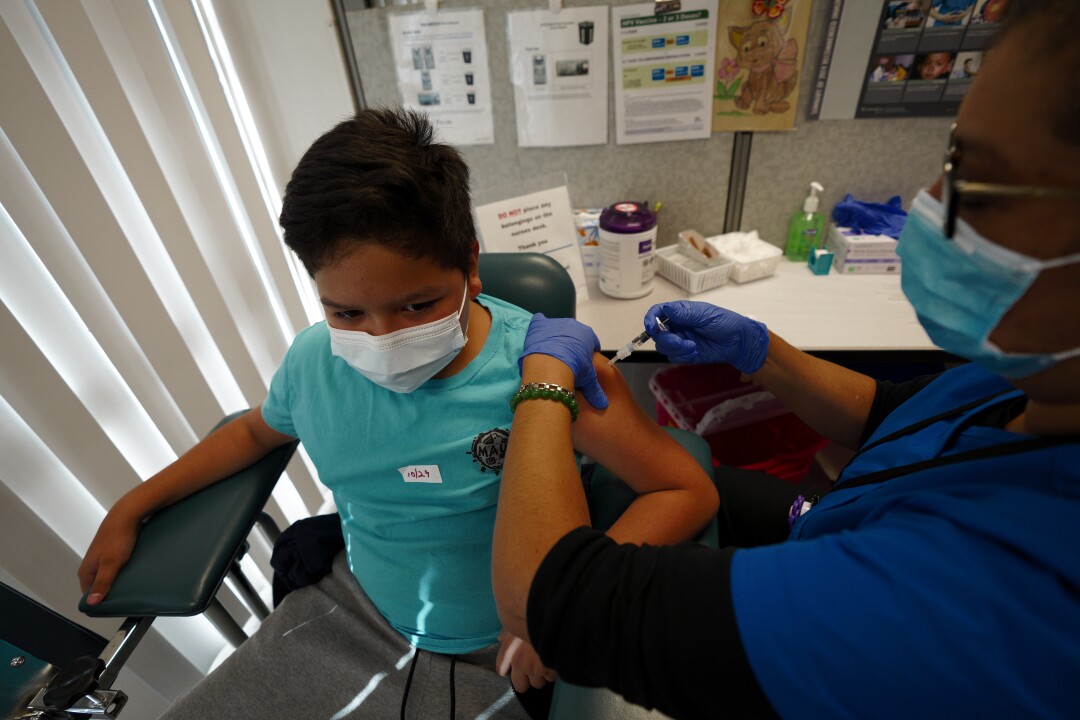 Окружная медсестра Кармен Гомес сделала Хулио Ибарру прививку от гриппа.