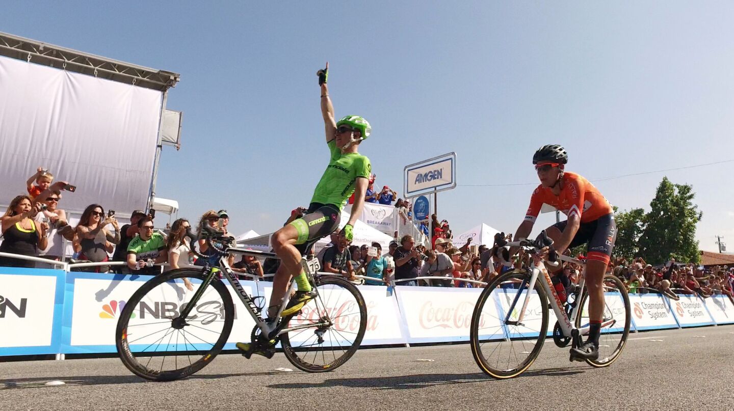 Ben King raises his hand in the air after edging out Evan Huffman to win stage 2 of the Tour of California in Santa Clarita on May 16.