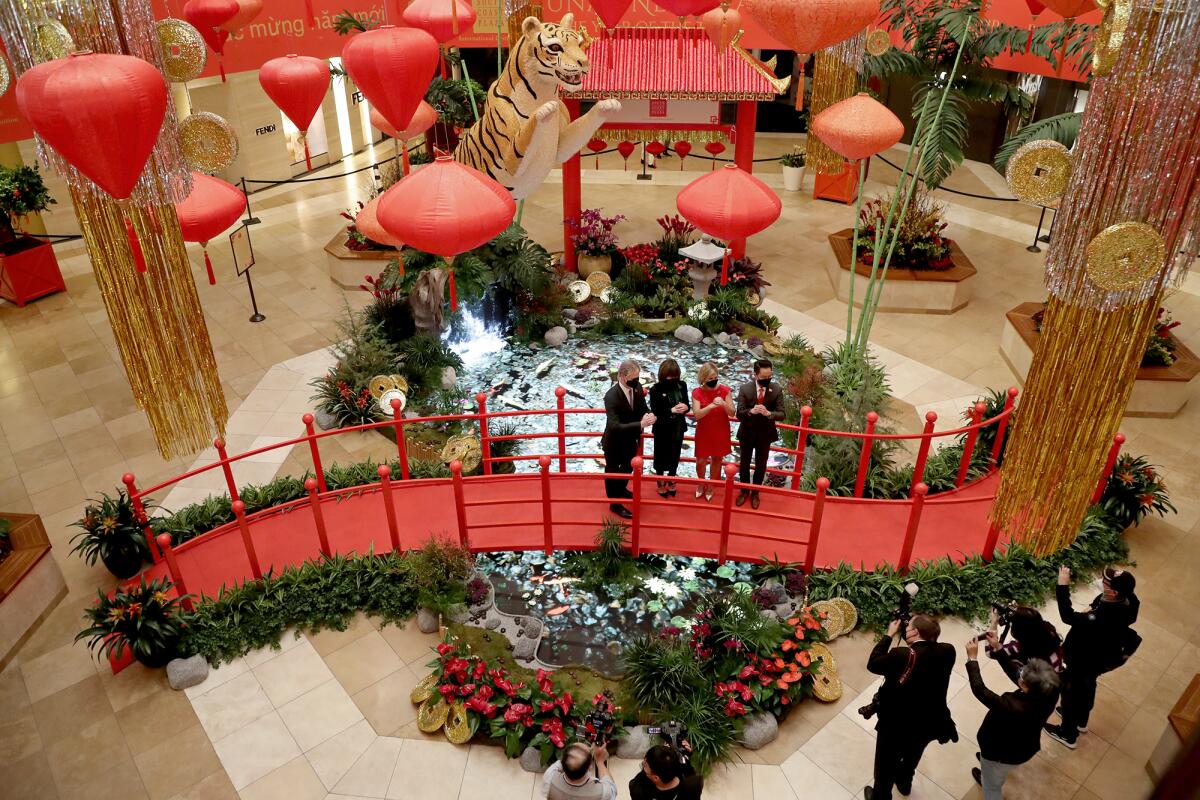 South Coast Plaza officials stand over a digital koi pond Thursday during the debut of a 12th annual Lunar New Year event.