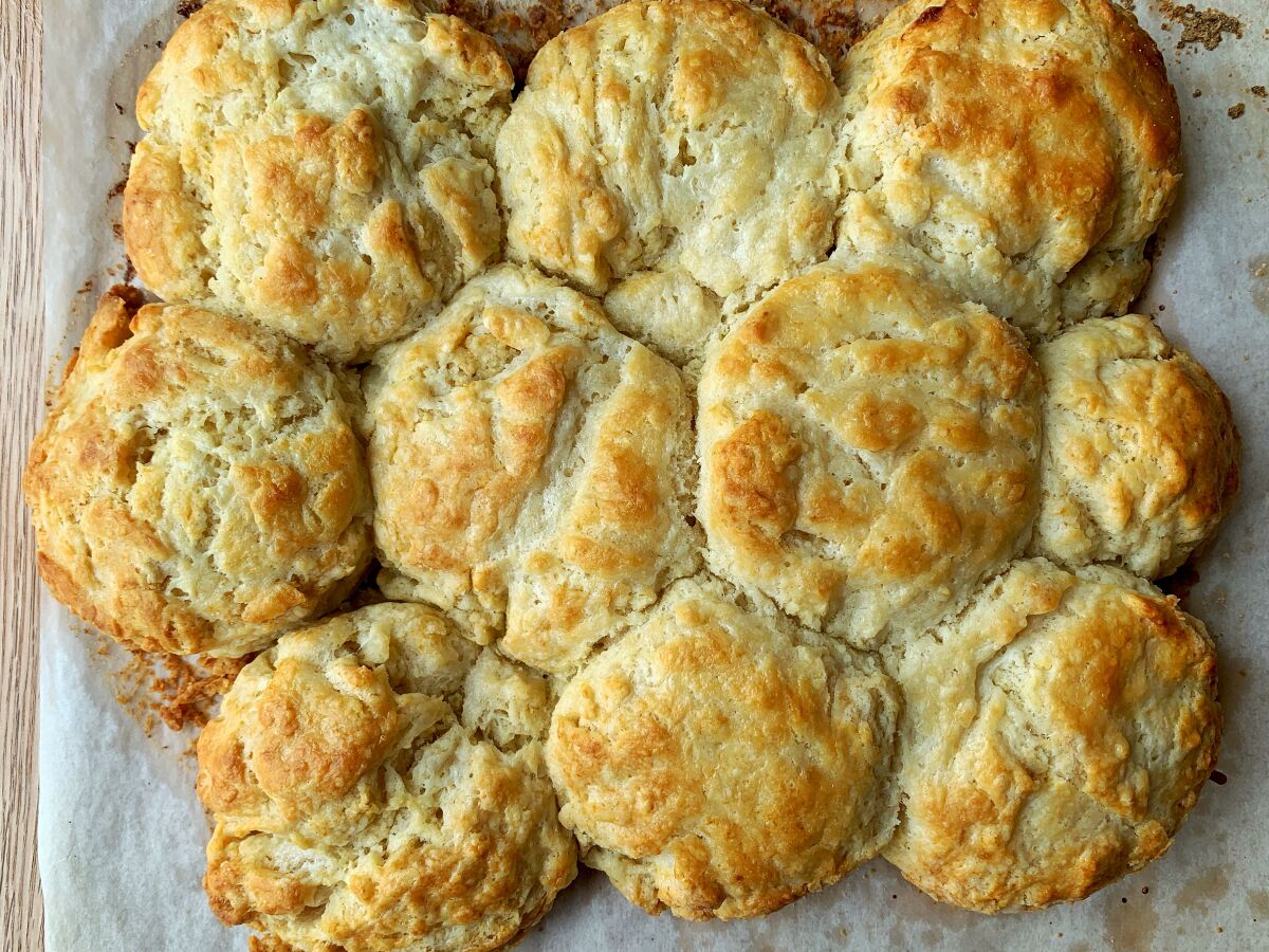 Arranging biscuits so they touch before baking allows them to rise better and gives them fluffier edges.
