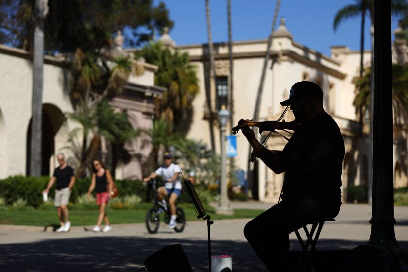 Josue Gascot sits in the shade on a warm afternoon in Balboa Park and plays "Have You Ever Seen The Rain?." 