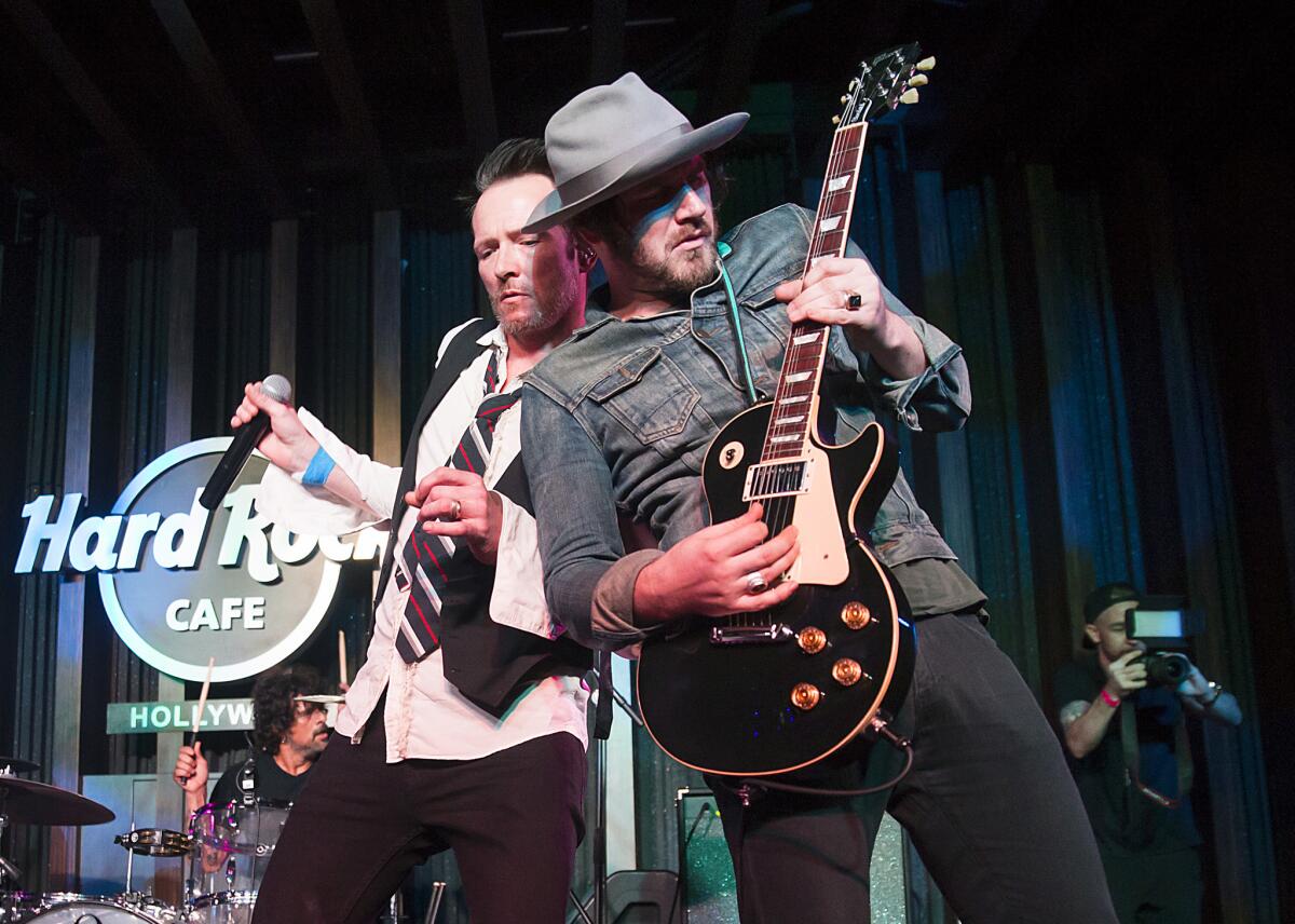 Scott Weiland, left, performs with bandmate Jeremy Brown during an exclusive listening party at Hard Rock Cafe Hollywood in Los Angeles on March 27. Brown died March 30 at his home in Venice. He was 34.