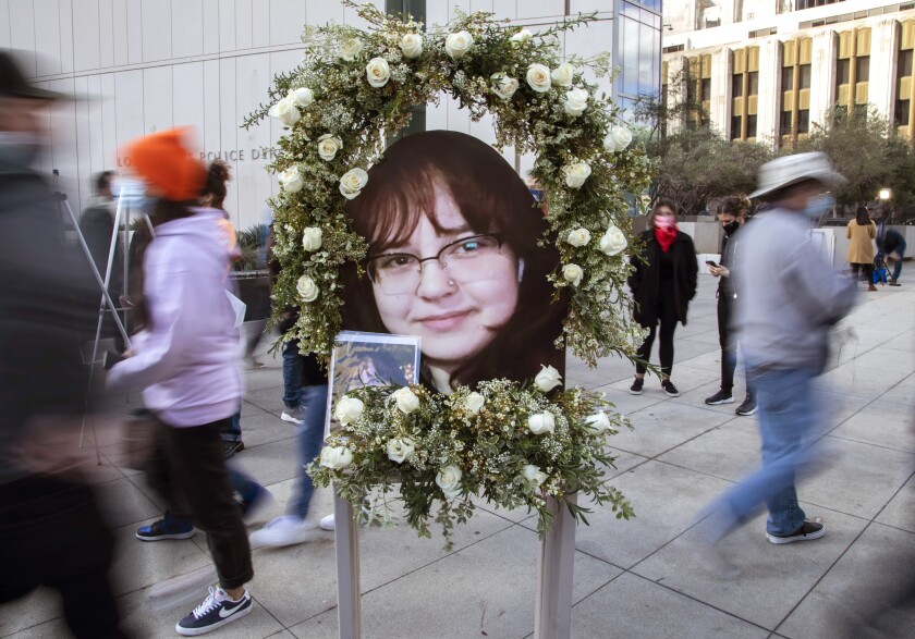 People walk past a photo and wreath honoring LAPD shooting victim Valentina Orellana-Peralta.