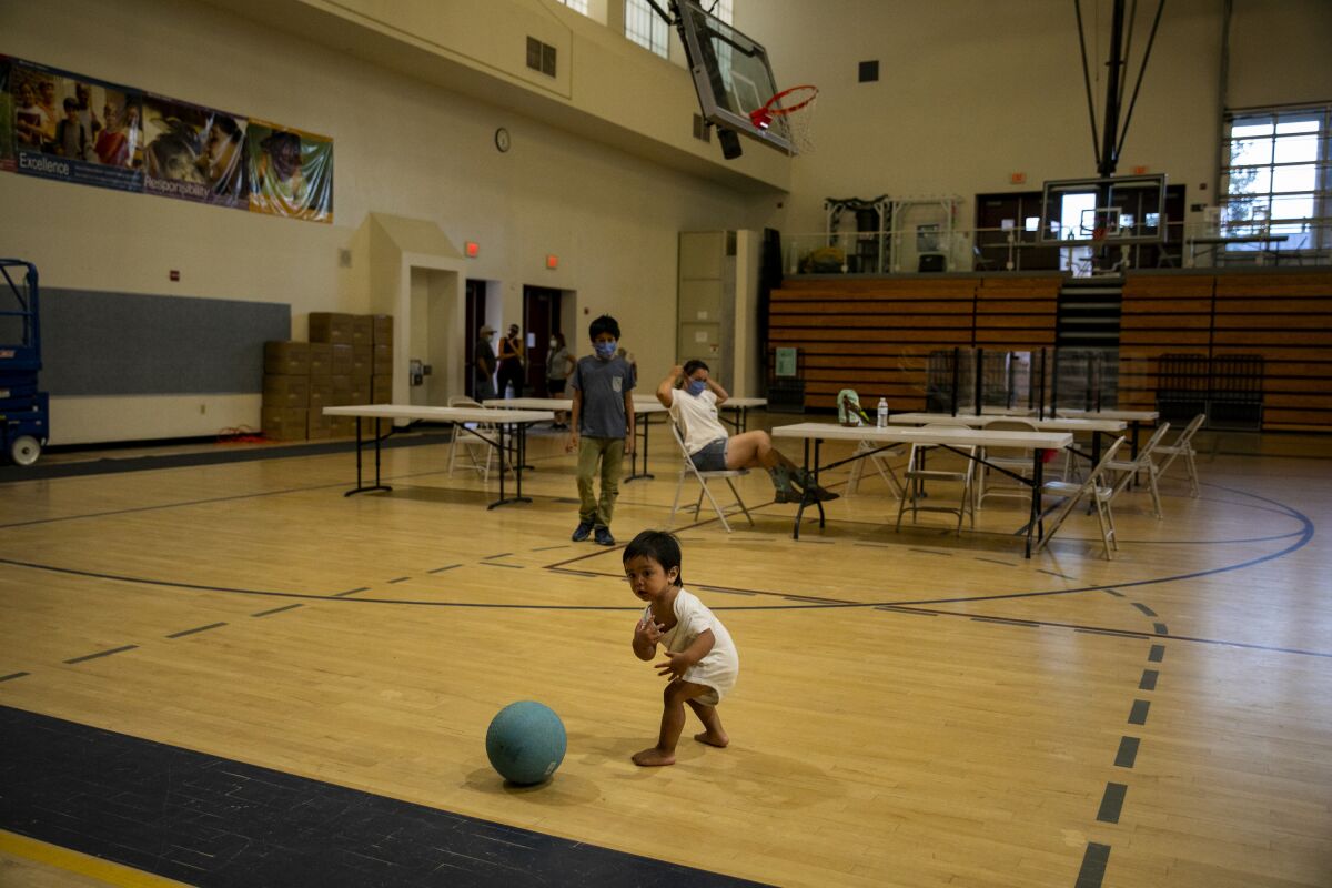 Felipe Arrieta, who is almost two years old, plays with a ball at an evacuation center at MacQueen Middle School.