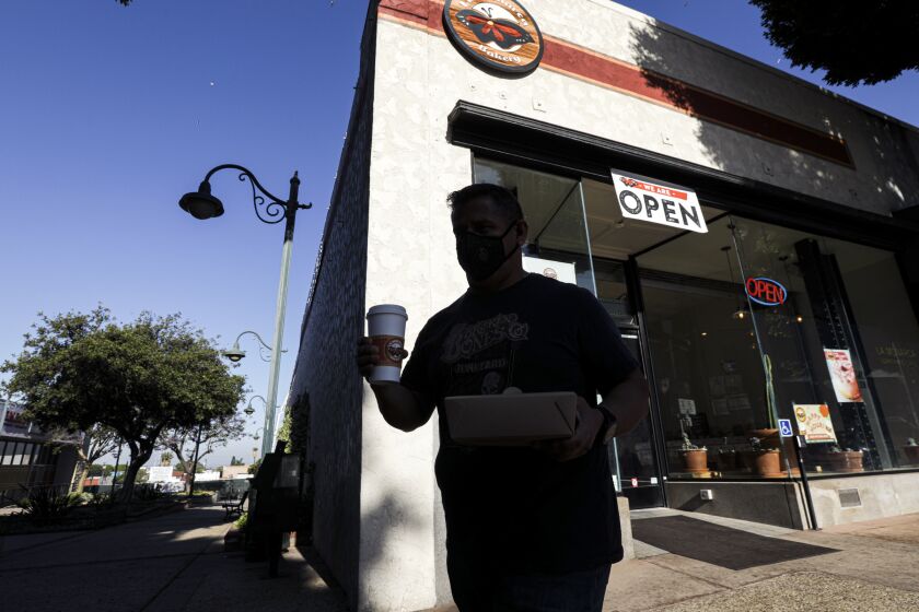 WHITTIER, CA - MAY 08: David Fernandez with his breakfast from La Monarca Bakery that is opened for take out orders on Friday, May 8, 2020 in Whittier, CA. (Irfan Khan / Los Angeles Times)