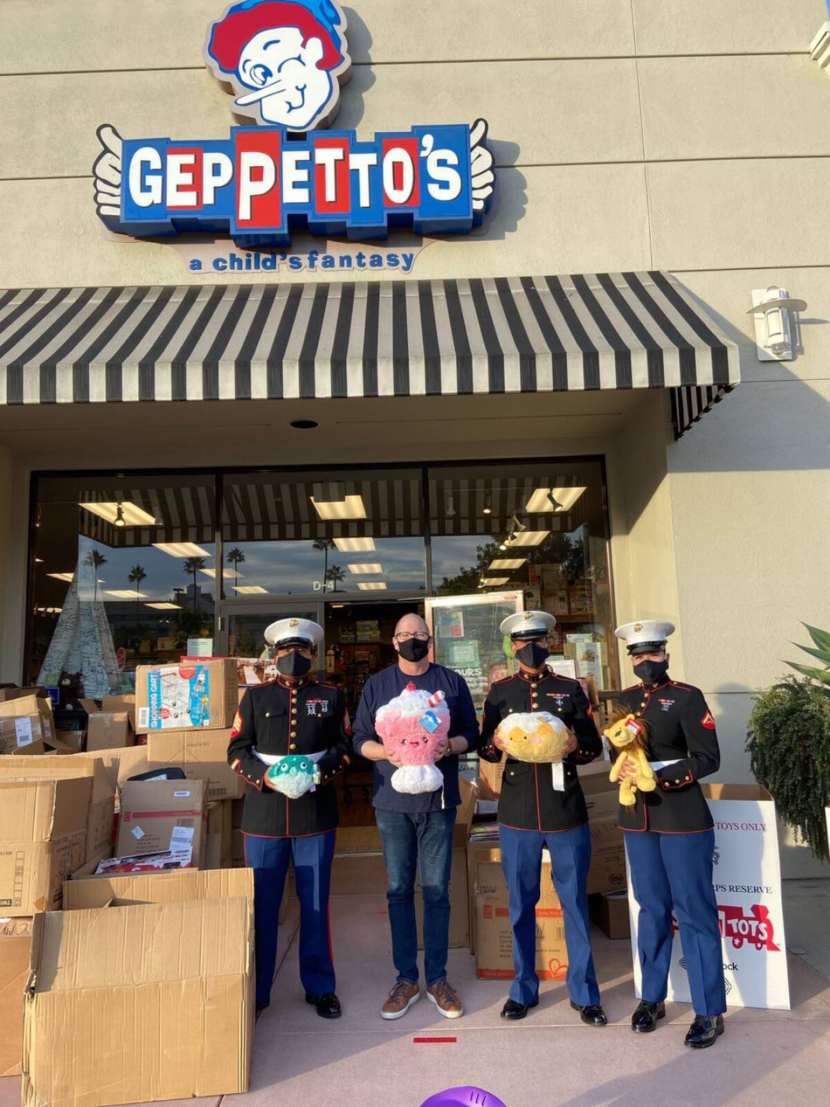 Geppetto's owner Brian Miller with the Marines and a large Toys for Tots haul.
