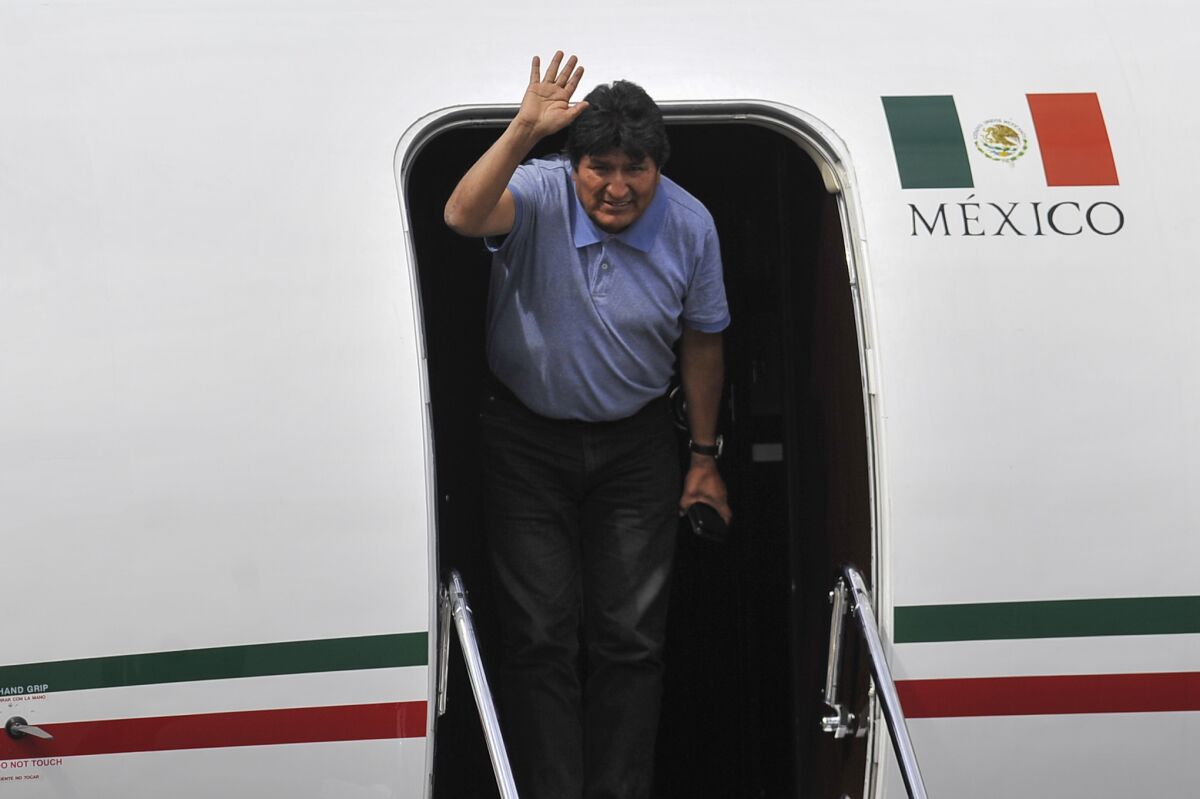 Former Bolivian President Evo Morales waves upon landing in Mexico City on Tuesday.