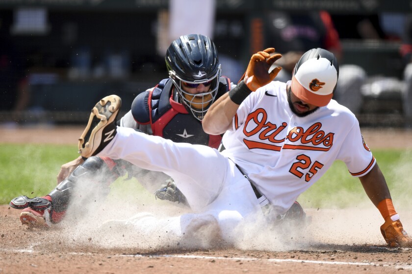 Baltimore Orioles' Anthony Santander, right, slides safely across home plate to score in front of Cleveland Indians catcher Rene Rivera, left, in the fourth inning of a baseball game, Sunday, June 6, 2021, in Baltimore. (AP Photo/Will Newton)