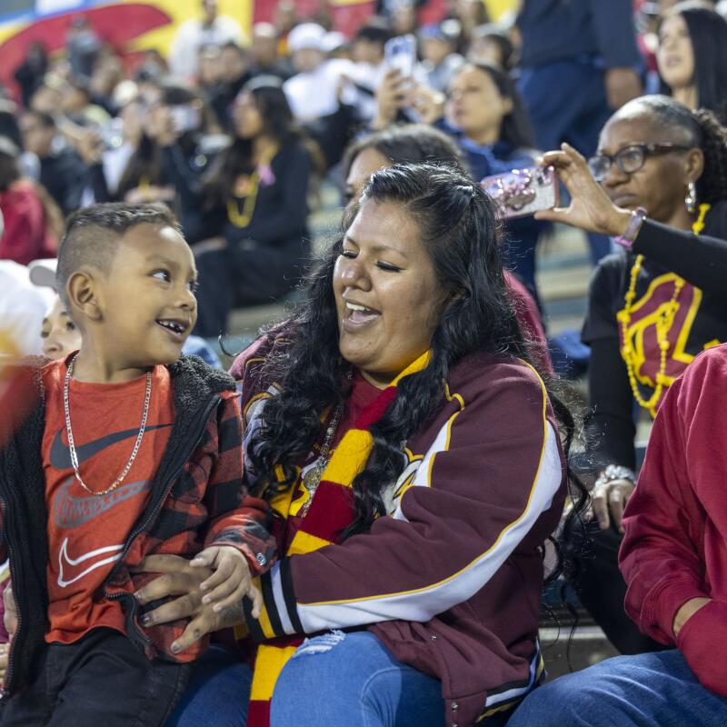 Angelica de Jesus, a Roosevelt grad, cheers on the Rough Riders with her family.