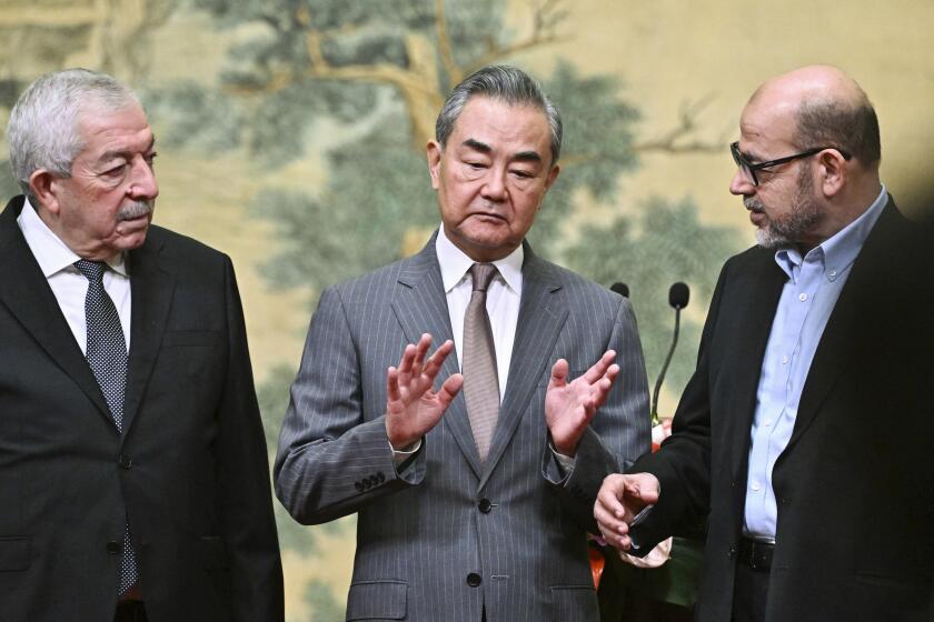 China's Foreign Minister Wang Yi, center, hosts an event for Mahmoud al-Aloul, left, vice chairman of Fatah, and Mussa Abu Marzuk, a senior member of Hamas, to meet at the Diaoyutai State Guesthouse in Beijing, Tuesday, July 23, 2024. (Pedro Pardo/Pool Photo via AP)