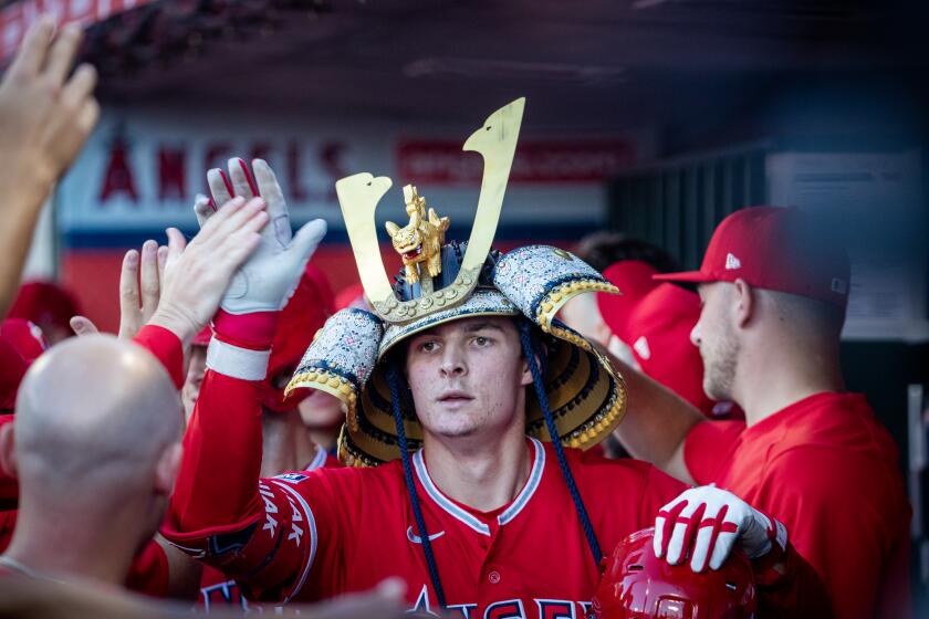 Anaheim, CA - July 18: Angels center fielder Mickey Moniak #16 is congratulated in the dugout after hitting a two-run home run in the first inning against the Yankees at Angel Stadium in Anaheim Tuesday, July 18, 2023. (Allen J. Schaben / Los Angeles Times)