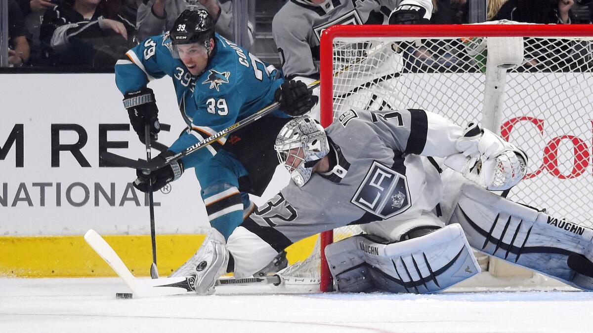 San Jose Sharks center Logan Couture, left, tries to move the puck past Kings goalie Jonathan Quick during the Kings' 4-1 win Saturday.