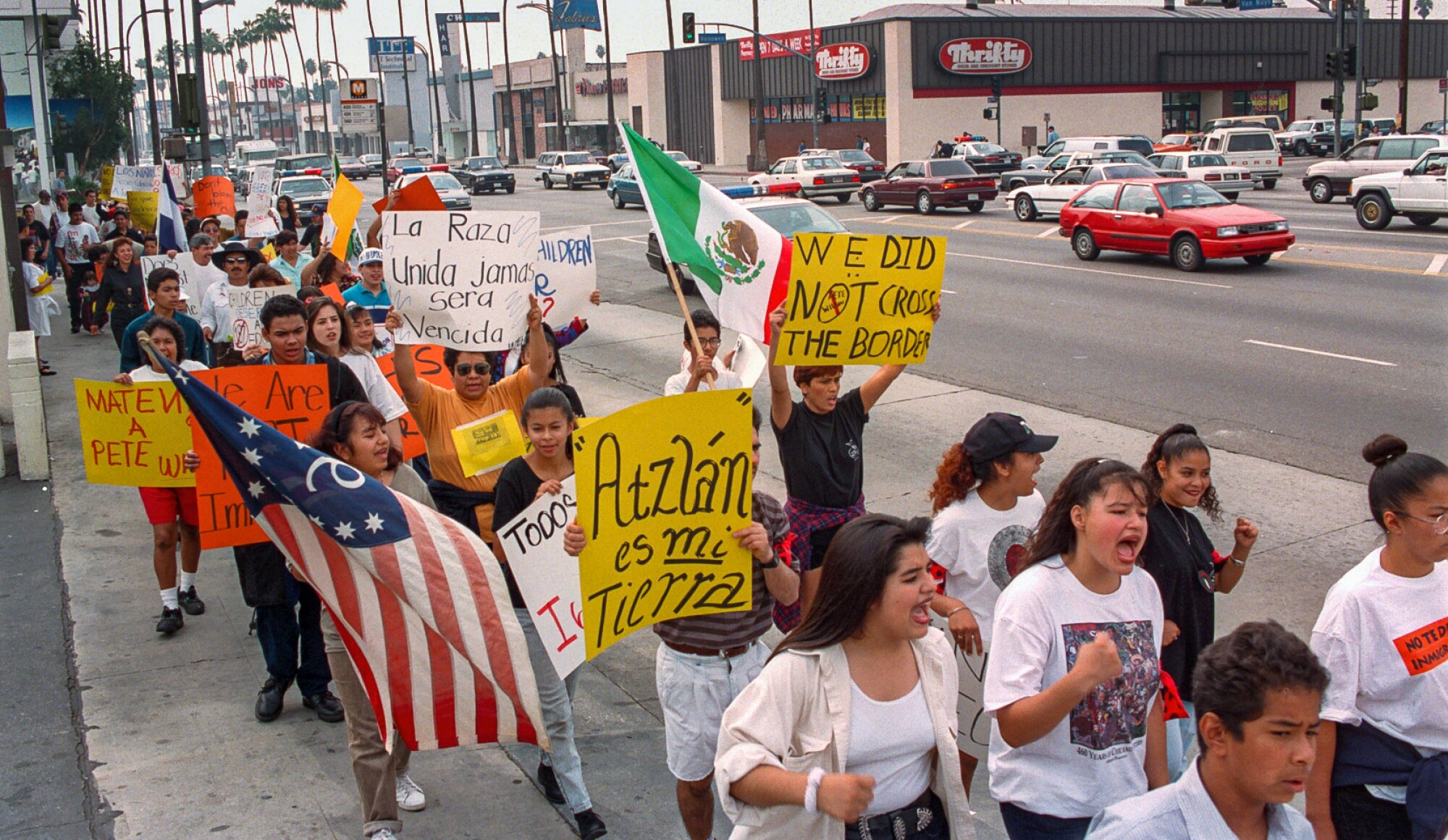 Students hold banners and flags during a walk-a-thon