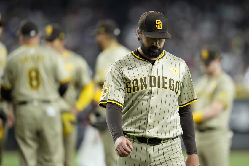 San Diego Padres starting pitcher Matt Waldron, right, walks off the field after being taken out by manager Mike Shildt (8) during the fourth inning of a baseball game against the Arizona Diamondbacks, Sunday, May 5, 2024, in Phoenix. (AP Photo/Ross D. Franklin)