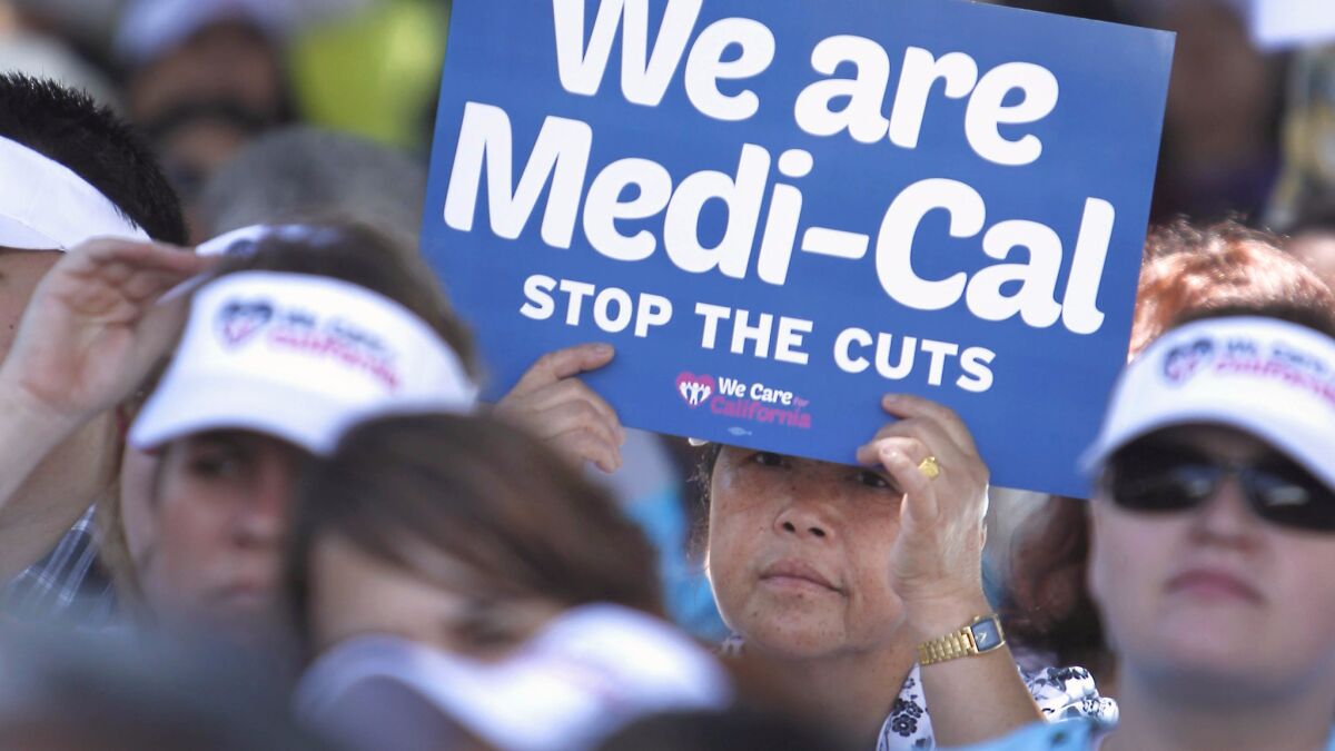 Sign-carrying demonstrators representing doctors, hospitals and unionized health care workers rally against cuts in the amount the state pays for Medi-Cal reimbursements in Sacramento in 2013.