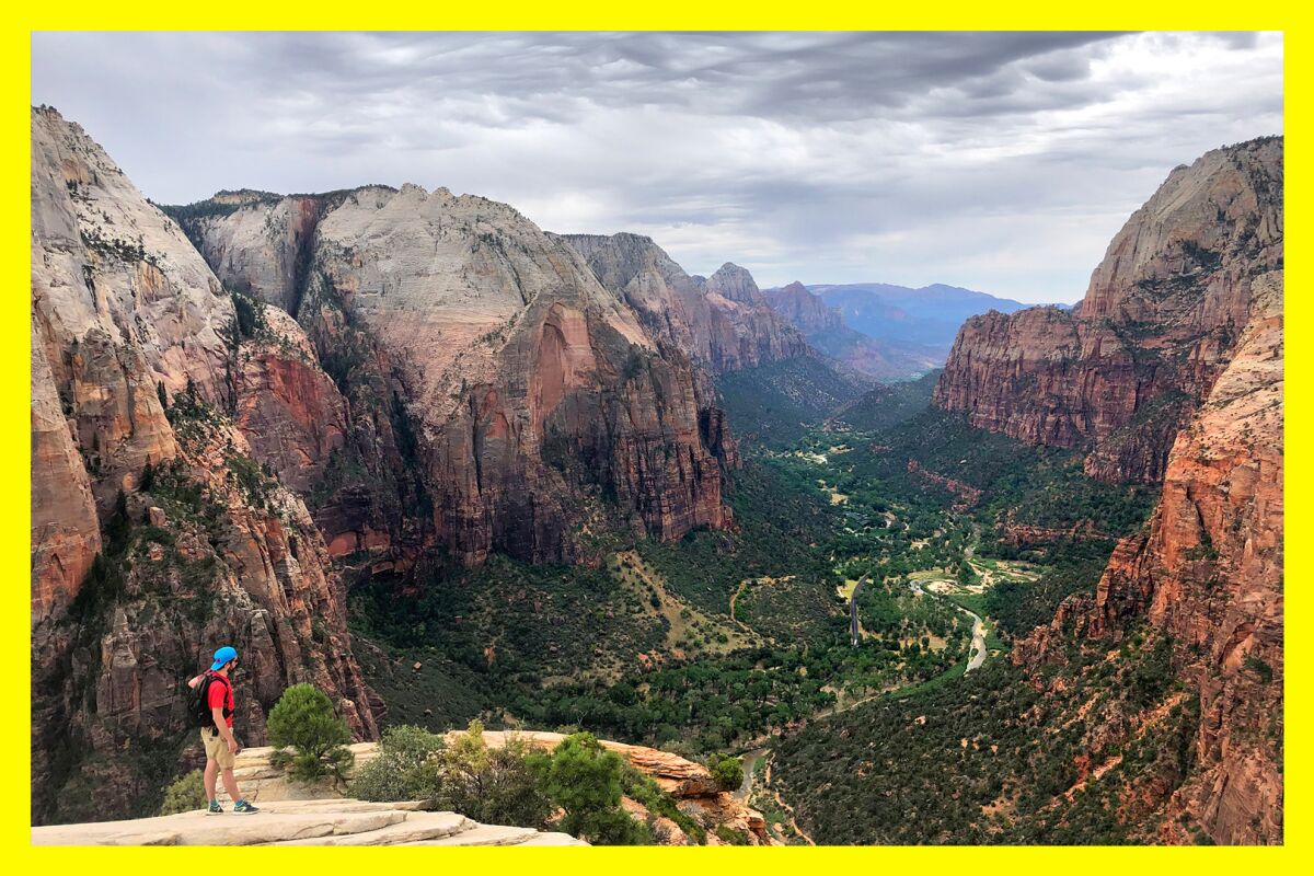 A hiker takes in the view from the top of Angels Landing in Zion National Park. 