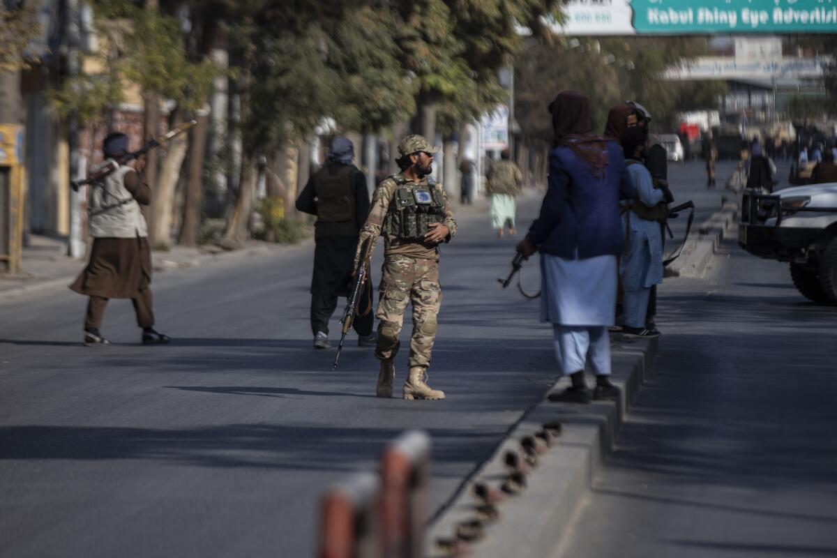 Taliban fighters blocking a road after an explosion