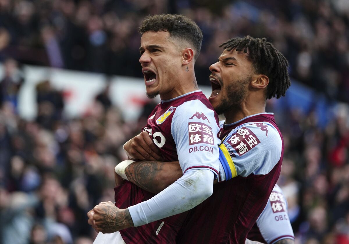 Aston Villa's Philippe Coutinho, left, celebrates scoring their side's third goal of the game with teammate Tyrone Mings during the English Premier League soccer match at Villa Park, Birmingham, England, Saturday, March 5, 2022. (David Davies/PA via AP)