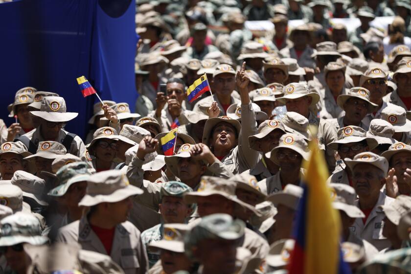 Miembros de la Milicia Bolivariana acuden a un acto para conmemorar el 22do aniversario del regreso del fallecido presidente Hugo Chávez al poder tras un fallido golpe de Estado, en Caracas, Venezuela, el 13 de abril de 2024. (AP Foto/Pedro Ramsee)