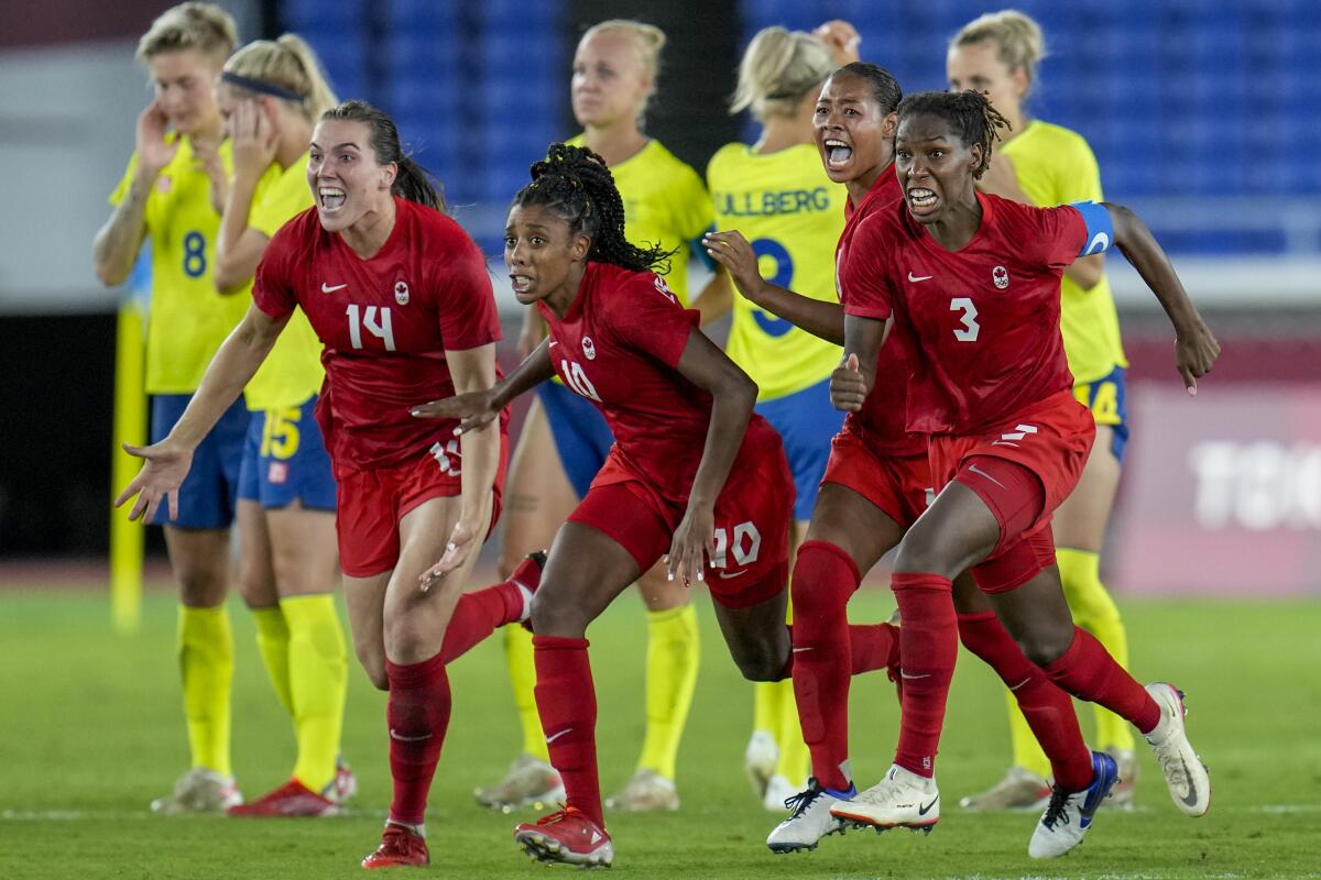 Players of Canada celebrate beating Sweden in a penalty shootout during the women's soccer match for the gold medal at the 2020 Summer Olympics, Friday, Aug. 6, 2021, in Yokohama, Japan. (AP Photo/Fernando Vergara)